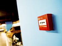 Fire alarm button on blue wall.